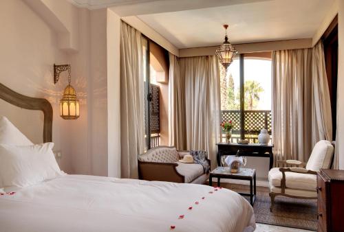 a hotel room with a bed and a chair and a desk at Palais de l'O in Marrakesh