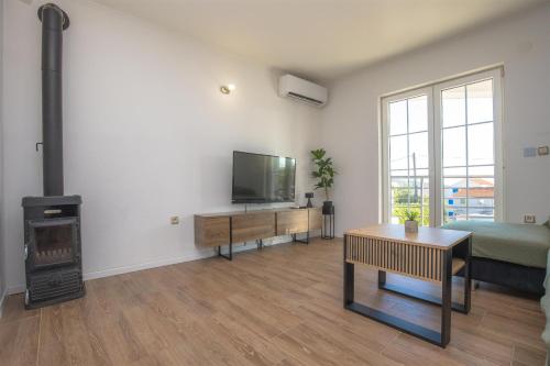 a living room with a television and a fireplace at House Matilda in Primošten