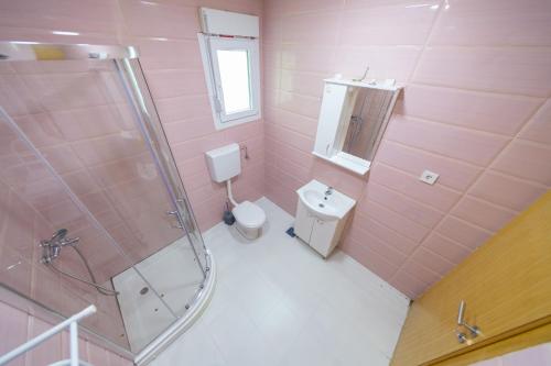 a pink bathroom with a toilet and a shower at Holiday Home Soul 