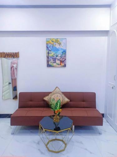 a living room with a red couch and a table at Hoàng Nga 2 Homestay in Phan Thiet