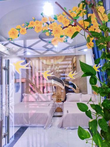 a bedroom with two beds with flowers on the ceiling at Hoàng Nga 2 Homestay in Phan Thiet
