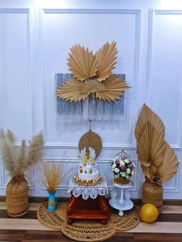 a table with a cake and some vases at Hoàng Nga 2 Homestay in Phan Thiet