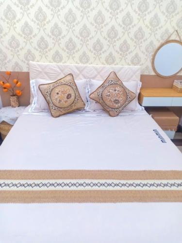 a white bed with two pillows on top of it at Hoàng Nga 2 Homestay in Phan Thiet