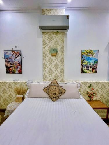 a bedroom with a large white bed with pillows at Hoàng Nga 2 Homestay in Phan Thiet