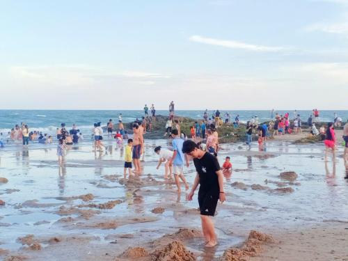 a group of people playing in the sand on the beach at Hoàng Nga 2 Homestay in Phan Thiet