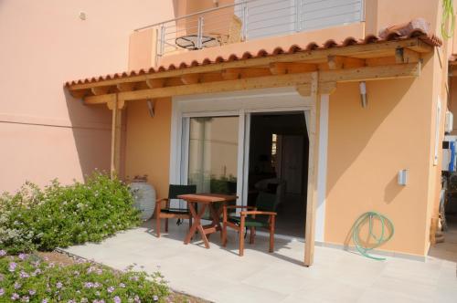 a patio with a table and a balcony at Aegean View Villa in Loutraki