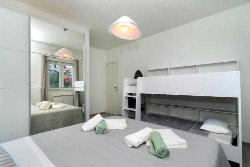 Un dormitorio blanco con dos camas y un espejo. en House Villa LuNi, en Brodarica