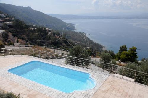a swimming pool with a view of the water at Aegean View Villa in Loutraki