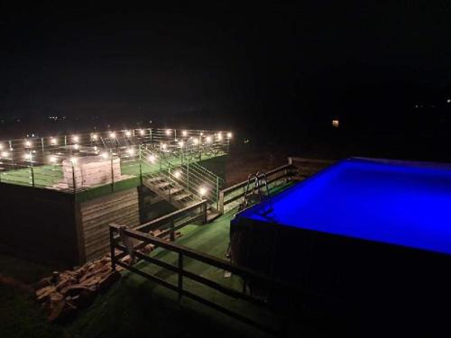 a lit up swimming pool at night with lights at Noclegi u Banysia w sercu Gór Świętokrzyskich in Krajno Pierwsze