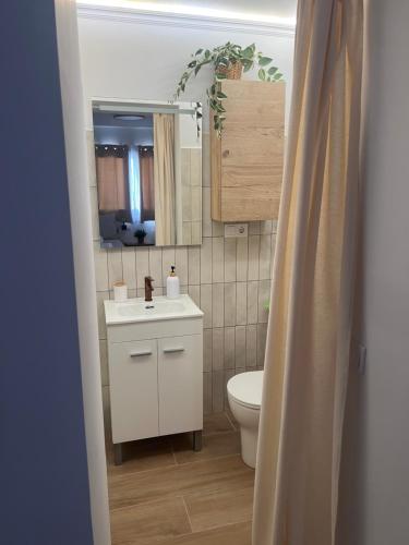 a bathroom with a white sink and a toilet at Casa Roberto in Alora