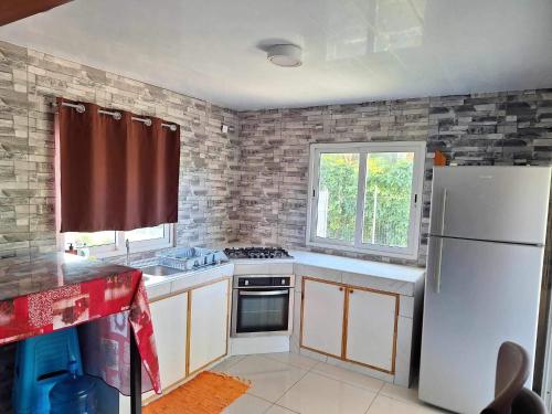 a kitchen with a white refrigerator and a window at Maina Lodge in Avatoru