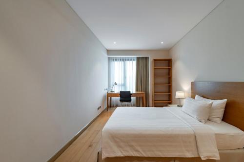 a hotel room with a bed and a desk at Sherwood Residence in Ho Chi Minh City