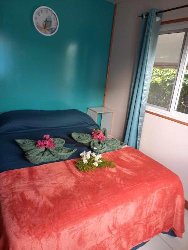 a bedroom with a bed with two flowers on it at Maina Lodge in Avatoru