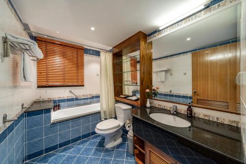 a bathroom with a toilet and a sink and a mirror at Sherwood Residence in Ho Chi Minh City