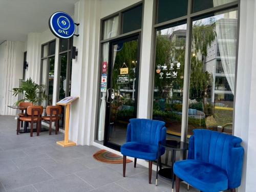 a store front with blue chairs and a table at The Quarter Chaophraya by UHG in Bangkok