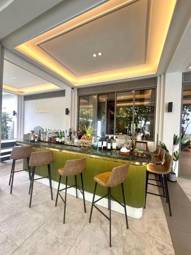 a bar in a lobby with chairs and a counter at The Quarter Chaophraya by UHG in Bangkok