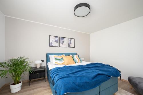 a bedroom with a bed with a blue blanket at Pärnu Pearl Residences in Pärnu