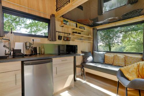 a kitchen with a bench in a tiny house at FORET TOTEM - Hébergements nature et bien-être en pleine forêt in Persquen