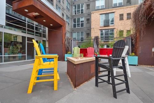 three colorful chairs sitting in front of a building at CozySuites Mill District with pool gym #12 in Minneapolis