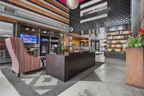 a lobby with a bar with a chair and a tv at CozySuites Mill District with pool gym #12 in Minneapolis