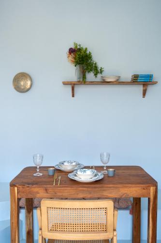 a wooden table with plates and glasses on it at Via Vasileia in Kattavía
