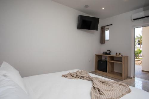 a bedroom with a bed with a tv on the wall at Olevia Comfort in Faliraki