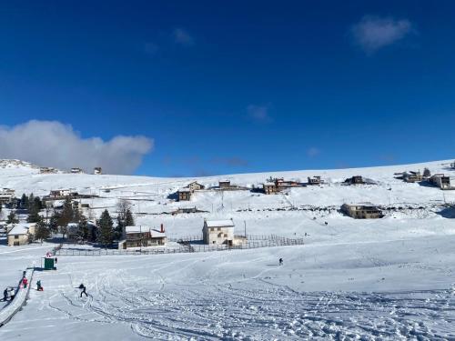 a group of people skiing down a snow covered slope at La casa nel bosco-Val Granara guesthouse in Filettino Graziani