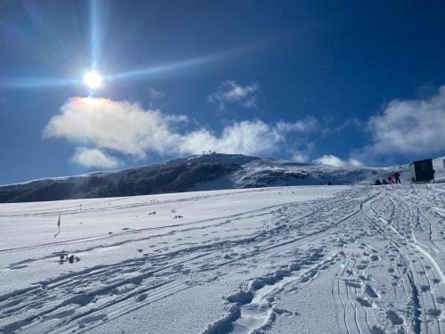 a snow covered slope with the sun in the sky at La casa nel bosco-Val Granara guesthouse in Filettino Graziani
