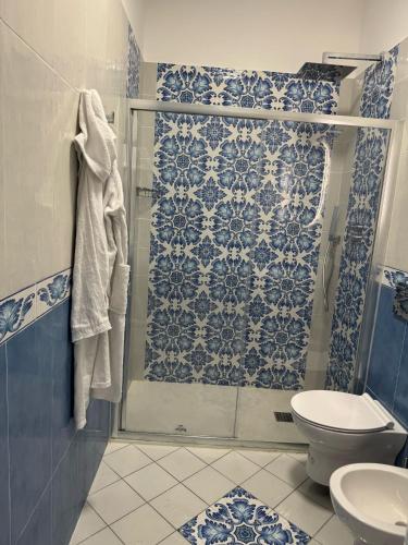 a blue and white bathroom with a shower and a toilet at Vincanto Maiori Costiera Amalfitana in Maiori
