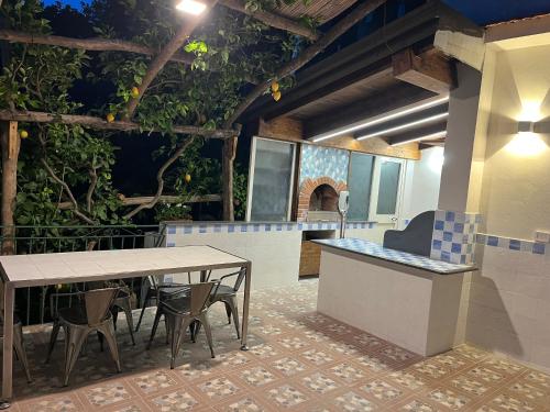 a patio with a table and chairs and an outdoor kitchen at Vincanto Maiori Costiera Amalfitana in Maiori
