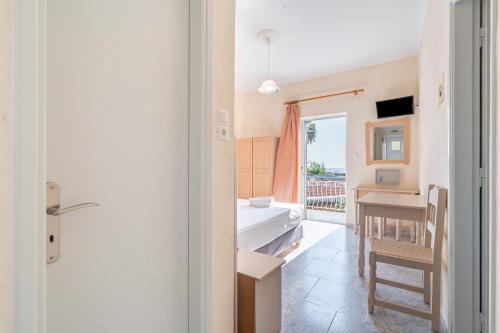 a room with a desk and a bed and a window at Alex bar apartments in Sarakiniko
