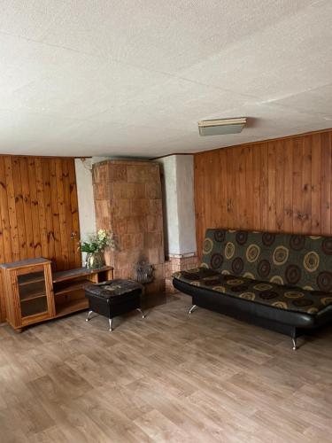 an empty room with a couch and a table at Lauku viesu māja Bajāri in Rucava