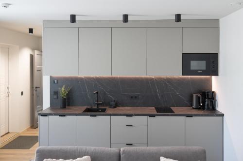 a kitchen with white cabinets and a counter at Pärnu Pearl Residences in Pärnu