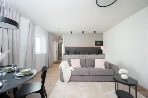 a living room with a couch and a table at Pärnu Pearl Residences in Pärnu