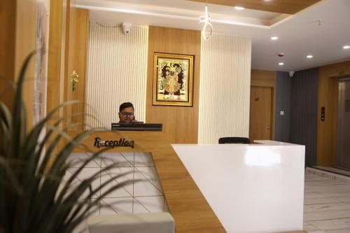 ドワルカにあるHotel The Grand Shivaの部屋のテーブルに座る男