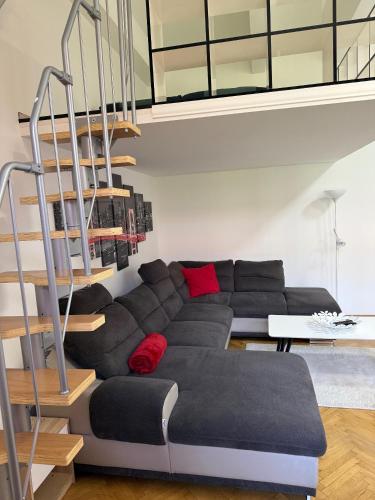 a living room with a couch and a staircase at Biztos Kuckó in Szeged