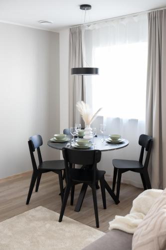 a dining room with a table and chairs and a window at Pärnu Pearl Residences in Pärnu