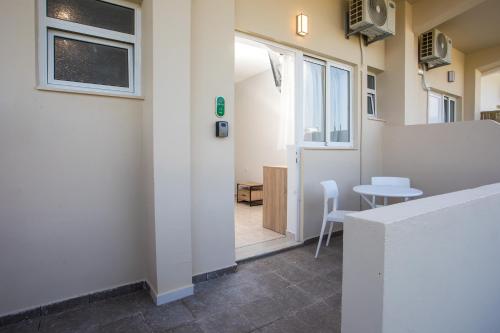 a room with a door and a table and chairs at Olevia Comfort in Faliraki