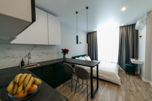 a kitchen with a sink and a bowl of fruit on a counter at VS Apartments in Kyiv