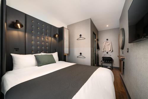 a bedroom with a large bed and a tv at Point A Hotel London Westminster in London
