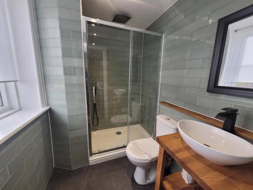 a bathroom with a toilet and a sink and a shower at New County Hotel & Serviced Apartments by RoomsBooked in Gloucester
