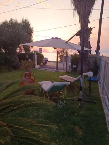 a table and a chair and an umbrella in the grass at Sunset Oasis in Roitika