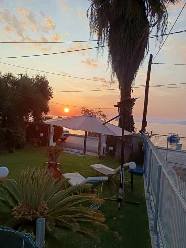 a sunset over the ocean with chairs and an umbrella at Sunset Oasis in Roitika