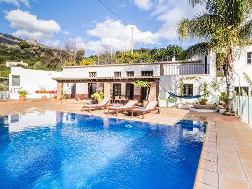 a swimming pool in front of a house at Molino Arroyo in Guájar-Faragüit