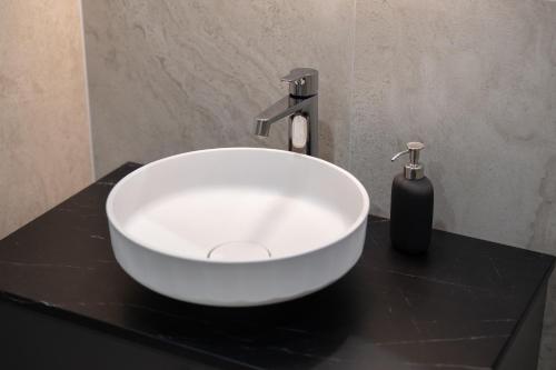 a white sink on a black counter in a bathroom at Pärnu Pearl Residences in Pärnu