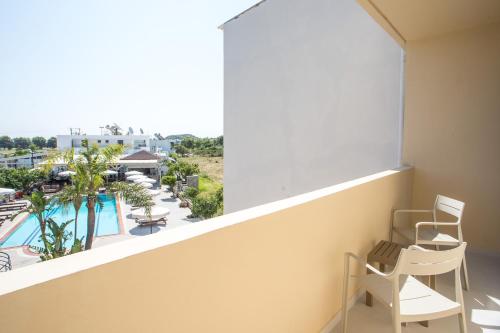 a balcony with chairs and a view of a pool at Olevia Comfort in Faliraki
