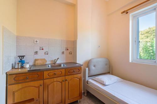 a small bathroom with a sink and a window at Alex bar apartments in Sarakiniko