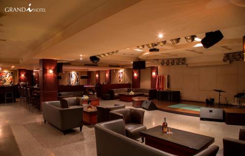 a lobby with chairs and tables and a bar at I Hotel Batam in Nagoya