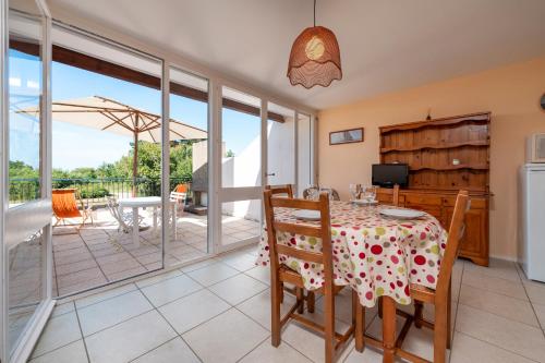 une salle à manger avec une table et un balcon dans l'établissement Appartement Arzon, à Arzon