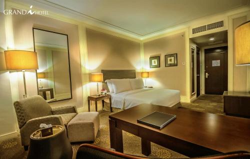 a hotel room with a bed and a table at I Hotel Batam in Nagoya